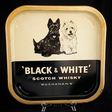 Load image into Gallery viewer, Cool vintage promotional serving tray for &quot;Black &amp; White&quot; Scotch Whiskey &quot;Buchanan&#39;s&quot; with a pair of black and white Scotty dogs. England, circa 1950s.  In as found vintage condition.   Measures 13 3/4 x 13 3/4 x 1 inches
