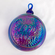 Load image into Gallery viewer, Vintage iridescent blue carnival glass Christmas ornament with house scene on one side and &quot;Home for the Holidays 1990&quot; on the other. The sides have a ribbed detail. A beautiful piece of mold blown glass with an applied blown glass hanger. It&#39;s absolutely stunning!  In excellent condition, no chips or cracks. Maker unknown.  Measures 3-1/4&quot; x 1-3/4&quot;
