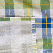 Load image into Gallery viewer, Bright and cheery white cotton linen vintage tablecloth with a plaid design of blue, green and yellow.   In excellent condition, free from tears/stains. One edge has a hand sewn repair.  Measures 48 x 67 inches 
