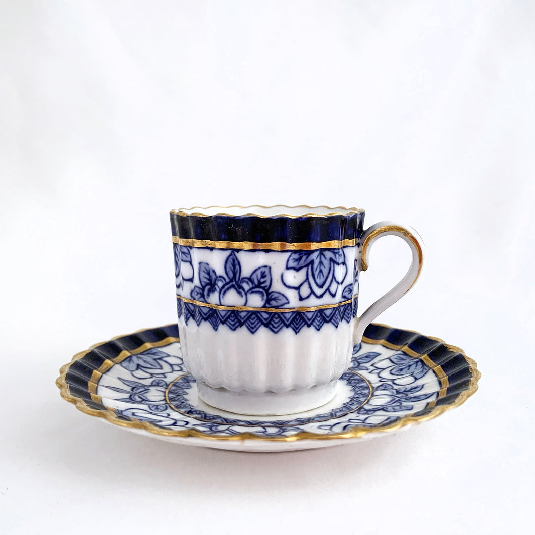 Antique porcelain demitasse cup and saucer hand painted in cobalt blue and white florals, geometric band with gold gilt details. The cup has a lovely vertically ribbed or scalloped shape. Produced by Spode Copeland, England, circa 1900.  In excellent condition, free from chips/cracks/repairs. Impressed, stamped and painted marks.  Dimensions of cup 2
