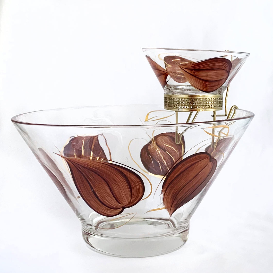 Super funky vintage chip and dip set painted on the outside with brown leaves and gold accents. Perfect for your next party, movie night, game night or get-together. There is no obvious wear on the glass. The small bowl fits nicely in the gold coloured metal hanger which secures it onto the large bowl. Produced by Anchor Hocking, USA, circa 1960s.  Excellent over condition, no chips or cracks.  Measurements: large bowl 9 1/2 x 4 inches | small bowl 5 x 2 1/4 inches