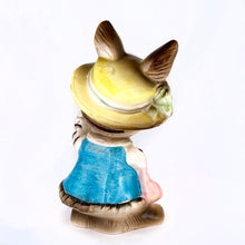 Load image into Gallery viewer, Adorable vintage figural brown bunny rabbit coin bank dressed in blue with a pink purse and yellow hat. Unmarked but likely made in Japan or Taiwan, circa 1970s. In great vintage condition with a flea bite to one of the feet.  Measures approximately 6&quot; tall.

