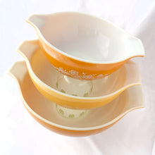 Load image into Gallery viewer, Vintage Butterfly Gold 2 Cinderella mixing bowls feature an asymmetrical flower and butterfly design in white on golden-orange or golden yellow ground. Designed by Gregory Mirow and produced by PYREX between 1979-1981. In excellent condition, shiny, free from chips/cracks. Size 442: 1 1/2 quart, measures 9 1/4 x 3 1/2 inches (golden orange bowl) Size 443: 2 1/2 quart, measures 10 3/4 x 3 7/8 inches (golden yellow bowl) Size 444: 4 quart, measures 13 x 4 3/8 inches (golden orange bowl)
