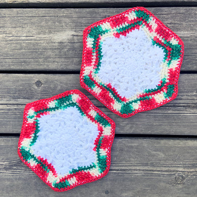 Set of two hand crocheted Christmas themed hexagon-shaped white pot holders or table protectors, with green and red details.  In excellent condition.  Measures 8