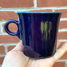 Load image into Gallery viewer, Fiestaware cobalt blue ring-handled mug. The style and durability of this restaurantware can&#39;t be beat! Produced by the Homer Laughlin Company, between 1986–2021. The great thing about the newer production is it is lead-free!  In excellent condition, free from chips/cracks. Marked on the bottom.  Measures 3 1/2 x 3 1/2 inches  Capacity 10-1/4 ounces
