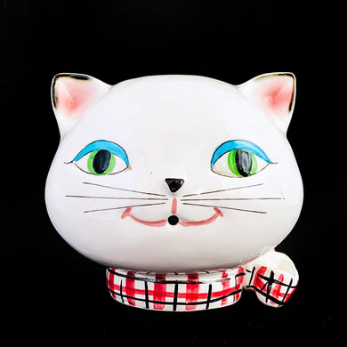 Vintage mid-century Cozy Kitten wall mounted ceramic string and scissor holder. Crafted by Holt Howard, Japan, 1958. This adorable collectible holds a ball of string which can be threaded through the mouth along with a pink, black and white checked collar with bow for holding scissors.

In as found vintage condition, hairline crack across face, see photos. Despite its flaw, the kitty is a great collectible that will look super cute mounted on the wall or sitting on a shelf to complement kitsch decor.