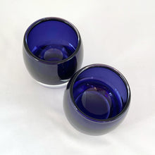 Load image into Gallery viewer, Add some ambiance to spa time or a special occasion with this pair of striking hand blown glass votive candle holders with clear bottoms and an cobalt blue body. They are gorgeous!  In excellent vintage condition, free from chips.  Measures 3 x 3 1/4 inches
