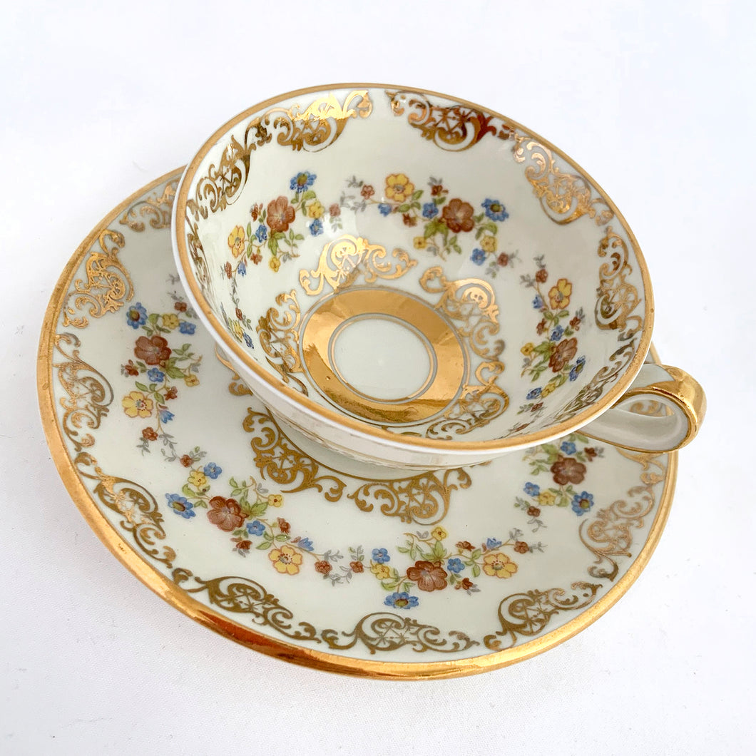 Vintage white porcelain demitasse cup and saucer beautifully decorated with colourful flowers and gold gilt details. Produced by Artibus of Portugal, circa 1940 - 1980.  In excellent condition, free from chips/cracks.  Dimensions of cup 3-1/8