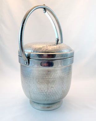 Vintage hammered aluminium ice bucket with self lifting handle on the lid. Marked Made in Italy.  In great vintage condition.  Measures 6 1/4 x 7 1/2 inches