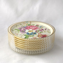Load image into Gallery viewer, Pretty set of six melmac coasters decorated in a colourful spring flowers design with a clear plastic holder. Crafted by Asian, India, circa 1980.  In excellent vintage condition.  4 inch diameter   
