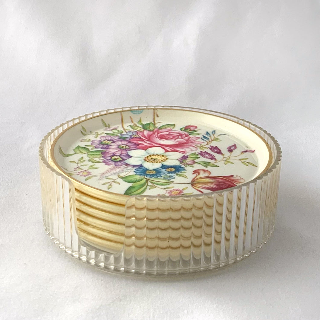 Pretty set of six melmac coasters decorated in a colourful spring flowers design with a clear plastic holder. Crafted by Asian, India, circa 1980.  In excellent vintage condition.  4 inch diameter   