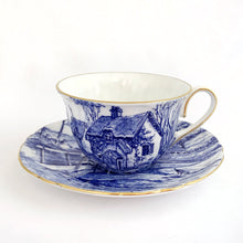 Load image into Gallery viewer, A rare vintage &quot;Glorius Devon&quot; cup and saucer. Just love the pretty blue pastoral landscape on white with scalloped shape and gold trim. Produced by Shelley in England, between 1940 - 1966.  Marked on the bottom with backstamp and the number &quot; 12734&quot;  Cup 3&quot; x 1-7/8&quot;  Saucer 4-5/8&quot;

