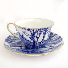 Load image into Gallery viewer, A rare vintage &quot;Glorius Devon&quot; cup and saucer. Just love the pretty blue pastoral landscape on white with scalloped shape and gold trim. Produced by Shelley in England, between 1940 - 1966.  Marked on the bottom with backstamp and the number &quot;12734&quot;.  Cup 3 x 1 7/8 inches  Saucer 4 5/8 inches
