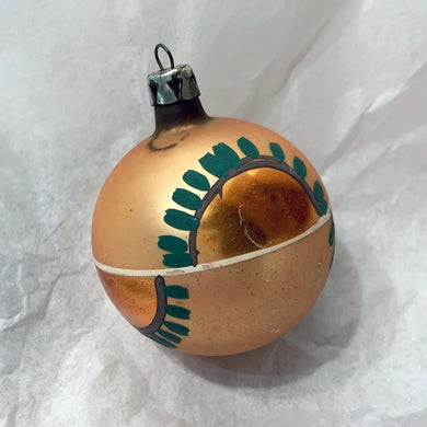 Vintage hand blown pale gold glass ball Christmas tree ornament with great patina and hand painted with gold and green graphic design. Marked Poland.  In vintage condition.  Measures 2