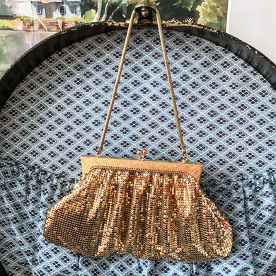 Gorgeous vintage art deco style gold toned metal mesh evening bag, lined with peachy-clay coloured fabric with pocket, kiss closure and serpentine chain handle. Designed by Whiting and Davis, made in the USA. A great period piece that would make an fabulous accessory!  Measurements: Width: 9-1/2