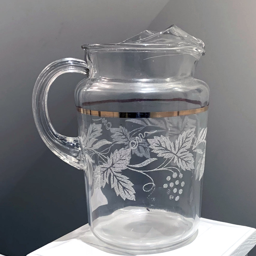 This large vintage pressed glass pitcher is perfect for water, lemonade, ice tea, beer or the bevvy of your choosing. It has an textured pattern of grapevines and a gold band, it has that handy ice lip too. Retro 1970s  In excellent condition, no chips or cracks.  Measures 5 3/4 x 9 inches  Capacity 64 ounces