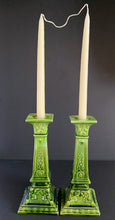 Load image into Gallery viewer, This RARE pair of antique candlesticks from Bretby Pottery are a stunning addition to any home. Crafted in pre-1920 England, they feature a moss green glaze with exquisite raised laurel leaves and rosettes. A must-have for the vintage collector!  In excellent condition. Bretby&#39;s sunburst impressed mark is on the bottom.  Measures 10 inches.
