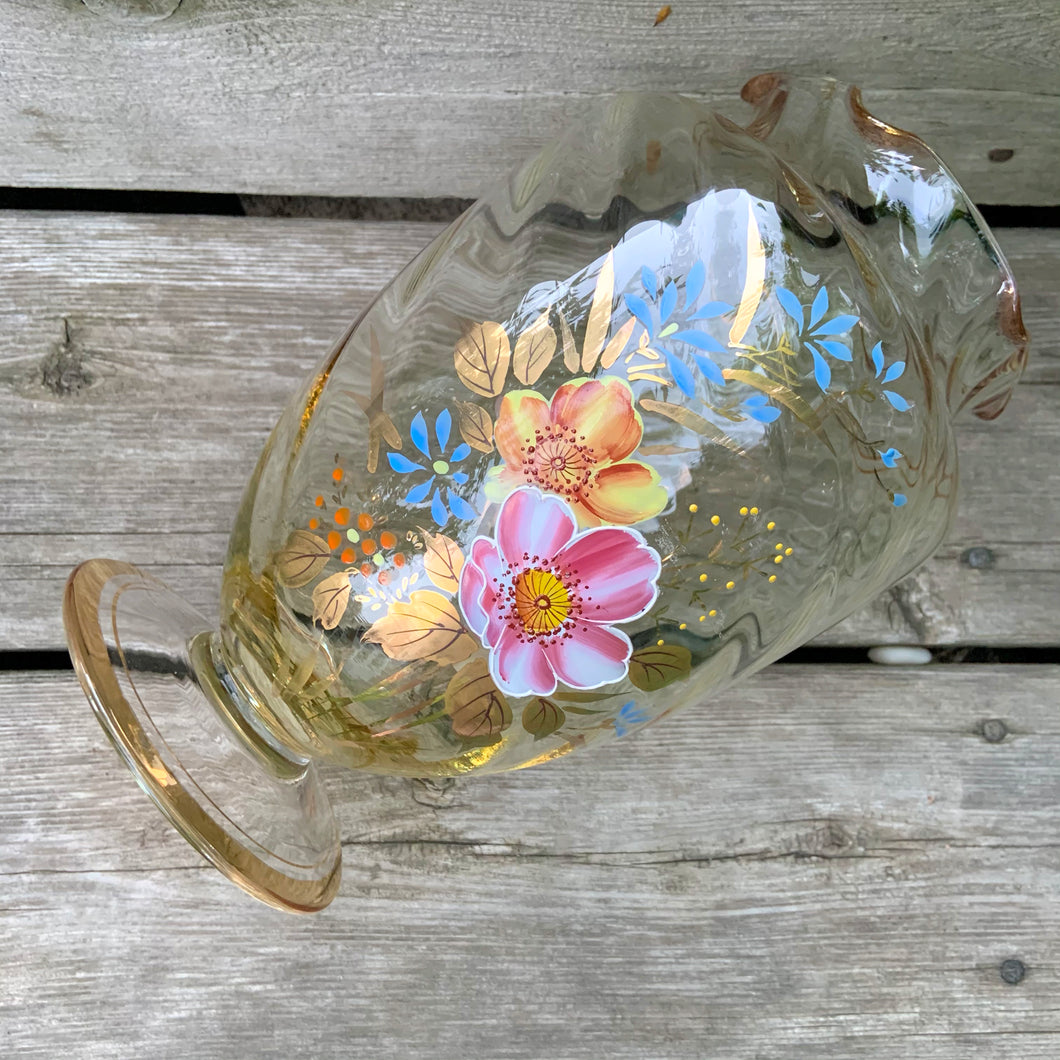 This is a lovely swirl optic glass urn-shaped footed vase with a ruffled edge. The hand painted enamel florals are beautifully done in shades of pink, yellow and blue with gold gilt leaves, bands and rim.  Overall excellent vintage condition, free from chips/cracks.  Measures 5 1/2 x 8 1/2 inches
