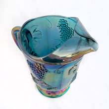 Load image into Gallery viewer, The words &quot;stunning&quot; and &quot;elegant&quot; embody this incredible blue carnival glass pitcher in the &quot;Harvest&quot; pattern of grapes and leaves. Made by Colony (Indiana) Glass Co. between 1973 - 1976. This pitcher would look amazing on any tablescape or use it for a beautiful floral bouquet.  In excellent condition, no chips or cracks.  Measures 6&quot; x 10&quot;, holds 64oz
