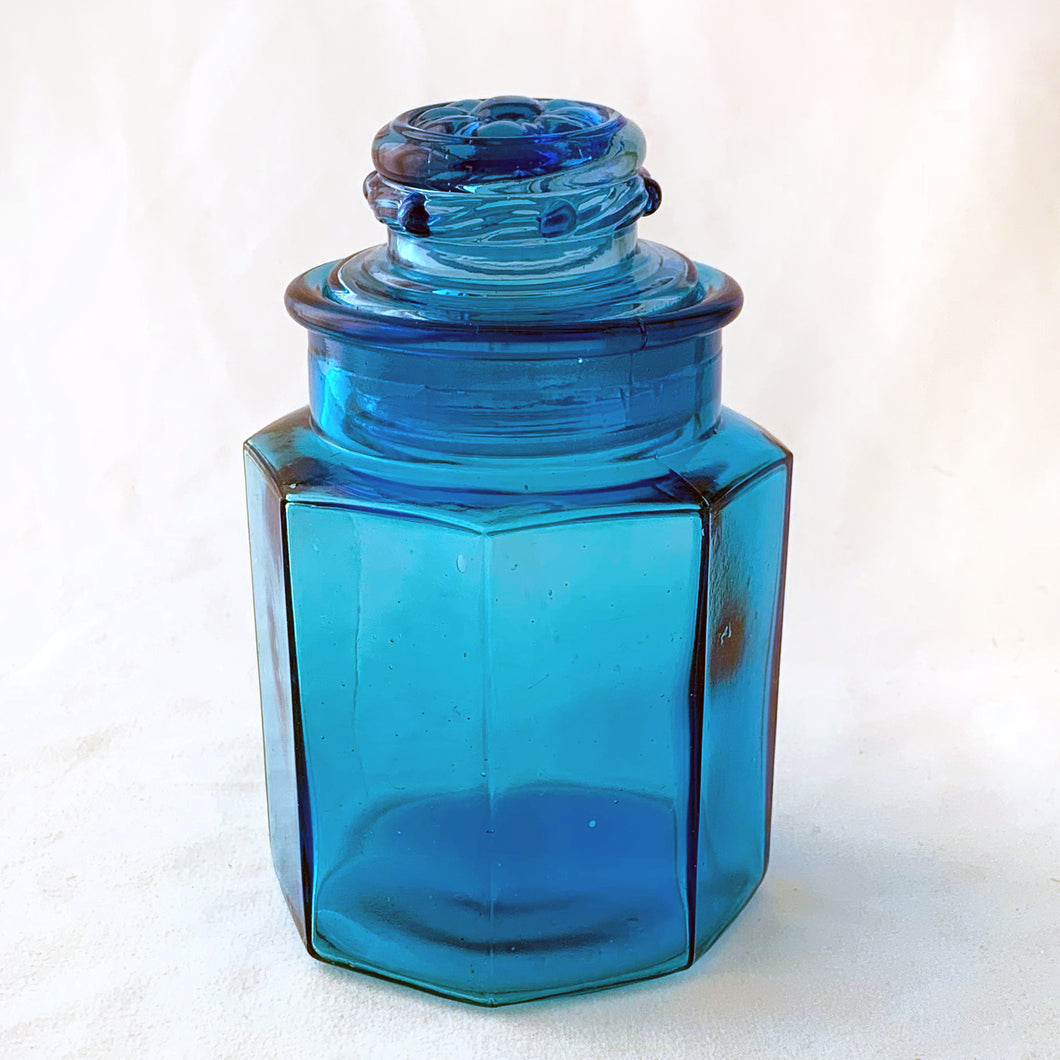 This vintage sky blue apothecary jar is perfect to store dry goods, bath accessories or as a beautiful display piece. Great hexagonal shape with a daisy on the top of the ground stopper. Takahashi Glass, Japan, circa 1970.  In excellent condition, no chips or cracks.  Measures 3 1/2 x 5 1/2 inches
