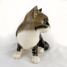 Load image into Gallery viewer, Highly desirable and collectible, this sweet vintage ceramic seated grey/brown striped tabby cat figurine has striking amber cathedral glass eyes (if you look at the eyes and move, the eyes will follow you). Produced by artist Mike Hinton, England (retired from Winstanley).  In excellent condition, free from chips/cracks. Signed by the artist and marked with the # 33 and England.  Dimensions: 5-1/4&quot; x 3-3/4&quot; x 5-3/4&quot;
