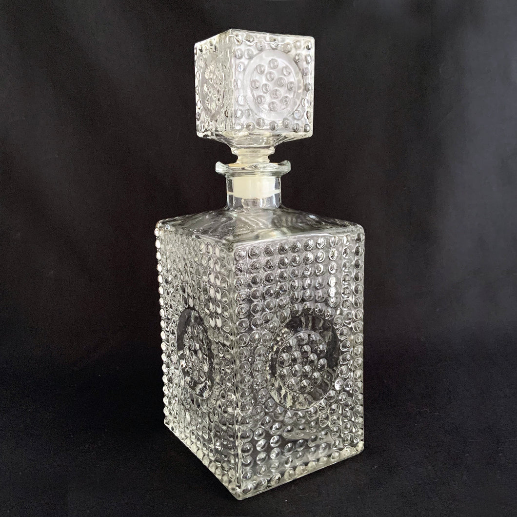 A vintage retro pressed glass liquor decanter with a hobnail pattern with circle on all sides with square hobnail stopper. Stopper has a plastic insert for a tight seal. A fabulous addition to your bar cart! This would even be a great decanter for fruit juices for your brunch buffet.  Excellent condition, no chips or cracks.  Measures 8