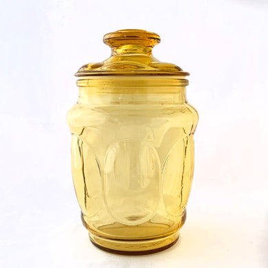This vintage honey gold glass kitchen canister jar which has a thumbprint pattern and comes with gasket fitted lids for a tight seal. This beautiful and practical storage container is perfect to add some flair to your kitchen counter, coffee bar, or laundry room.   In excellent condition, free from chips/cracks.  Measures 4 1/2 x 8 inches