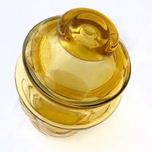 Load image into Gallery viewer, This vintage honey gold glass kitchen canister jar which has a thumbprint pattern and comes with gasket fitted lids for a tight seal. This beautiful and practical storage container is perfect to add some flair to your kitchen counter, coffee bar, or laundry room.   In excellent condition, free from chips/cracks.  Measures 4 1/2 x 8 inches
