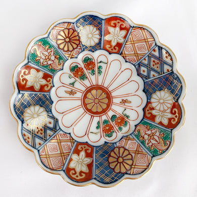 Vintage Imari style decorative sixteen petal chrysanthemum porcelain trinket dish hand painted in blue, red, turquoise and gold. Chinese characters on the base.  In excellent condition, free from chips/cracks/repairs.   Diameter 4