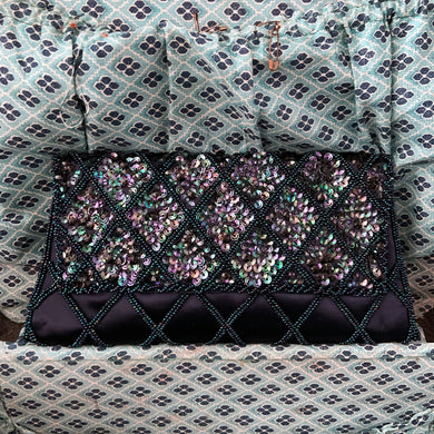 Gorgeous handmade mid-century vintage evening clutch bag covered in a diamond pattern of indigo blue seed beads and iridescent blue sequins with silver toned metal push button closure. The interior is lined with indigo coloured satin with a small pocket. The bag is large enough for a cell phone, credit cards/cash. Produced by Du-Val in Japan. An absolutely stunning piece that would make an incredible accessory. In overall excellent condition. Looks brand new