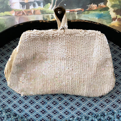 Gorgeous handmade mid-century vintage evening clutch bag covered in a  iridescent cream sequins with matching finger strap and kiss closure. The interior is lined with cream coloured satin with a small pocket. The bag is large enough for a cell phone, credit cards/cash. Made in Belgium. An absolutely stunning piece that would make an incredible accessory. In overall excellent condition.