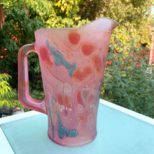 Load image into Gallery viewer, Beautiful vintage hand painted satin art glass handled pitcher in hues of pink, purple and shimmery gold. Produced by Rueven Studios, Israel. Circa 1980.  Dimensions: 5-5/8&quot; x 8-3/4&quot;  Capacity: 48oz
