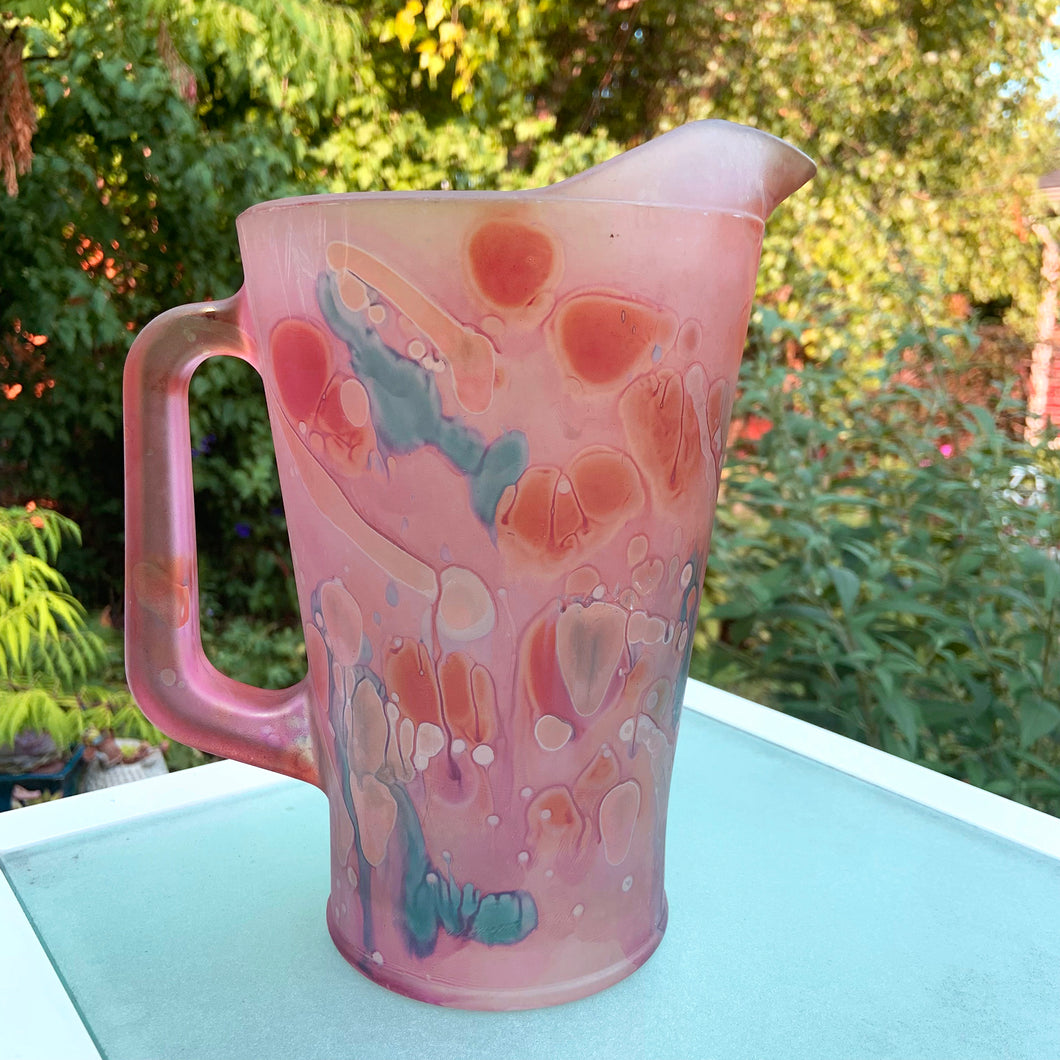 Beautiful vintage hand painted satin art glass handled pitcher in hues of pink, purple and shimmery gold. Produced by Rueven Studios, Israel. Circa 1980.  Dimensions: 5-5/8