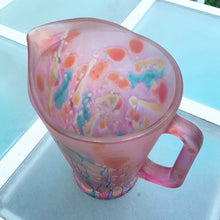 Load image into Gallery viewer, Beautiful vintage hand painted satin art glass handled pitcher in hues of pink, purple and shimmery gold. Produced by Rueven Studios, Israel. Circa 1980.  Dimensions: 5-5/8&quot; x 8-3/4&quot;  Capacity: 48oz
