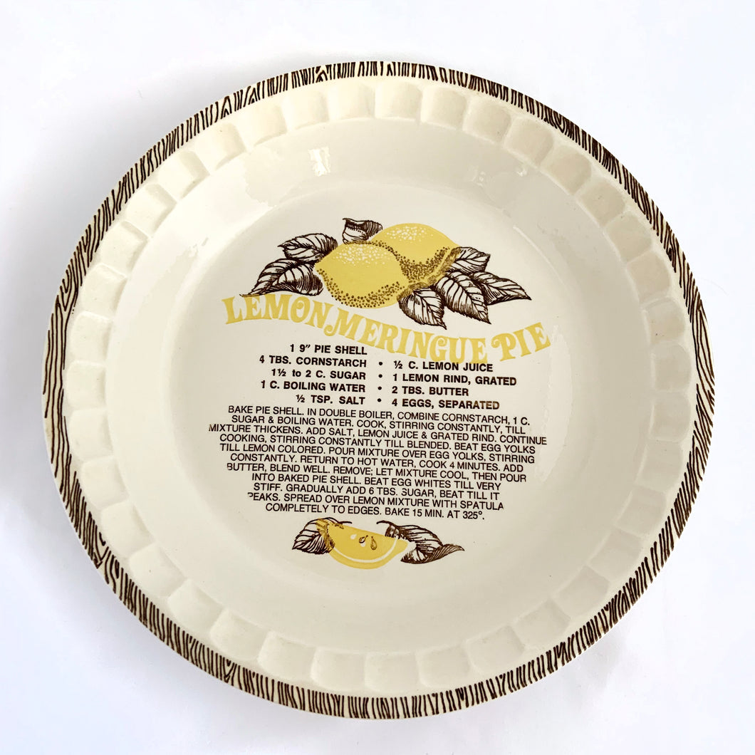 Vintage cream coloured glazed ceramic pie dish with lemon meringue pie recipe printed in the bottom of the dish in brown with yellow lemons and brown leaves. Royal China, produced by Jeannette Corporation in the USA. Conventional and microwave oven approved, dishwasher safe.  In excellent condition, free from chips/cracks.  Measures 10 7/8 x 1 3/4 inches and is made for a 9 inch pie