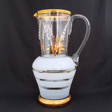 Vintage blown glass pitcher beautifully detailed with white Lily-of-the-Valley with gold leaves along with soft white and gold bands and applied blown glass handle. The perfect piece of serveware for spring and summer gatherings! Produced in Romania, circa 1950s.  In excellent condition, free from chips/cracks/wear.  Measures 5 x 11 1/8 inches