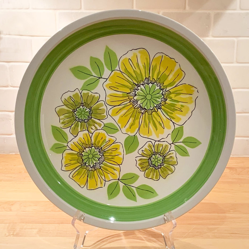 So nice to see a touch of Spring! We are loving this vibrant chop plate filled with yellow and green flowers in the 