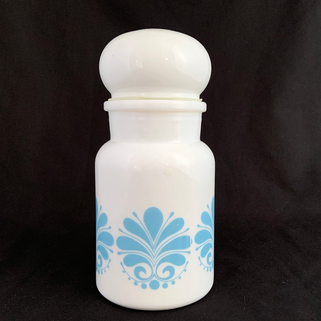 This vintage milk glass apothecary jar decorated with a blue geometric floral pattern topped off with a bubble-shaped lid. Could be used as a kitchen canister, bathroom apothecary jar or as a beautiful display piece. It has a plastic piece that makes a great seal if using for food storage. Marked on the bottom 