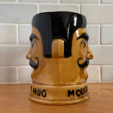 Load image into Gallery viewer, Fantastic vintage hand painted figural ceramic moustache mug in amber and brown, with a gentleman&#39;s face on each half of the mug with moustache guard and raised words &quot;MOUSTACHE MUG&quot; at the base. Produced by Price Kensington, England. Circa 1950.  In excellent vintage condition, free from chips, cracking; normal crazing present.  Measures 4&quot; x 5&quot;
