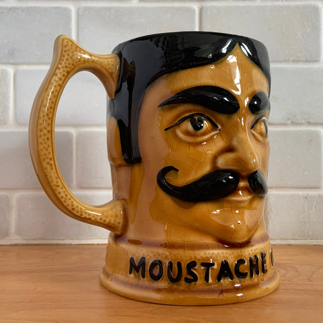 Fantastic vintage hand painted figural ceramic moustache mug in amber and brown, with a gentleman's face on each half of the mug with moustache guard and raised words 