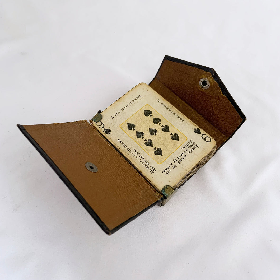 This rare deck of The Nile Fortune Telling Cards is fascinating. The backs are beautifully illustrated with an Egyptian sphynx and pyramids in reflection surrounded by florals. Each face card aside from the suit and number has four prophecies or sayings, somewhat similar to fortune cookie fortunes. The black case has a metal clip to hold the deck in place along with a snap button closure. Produced by the U.S. Playing Card Co. Cincinnati Ohio copyright 1897-1904. 