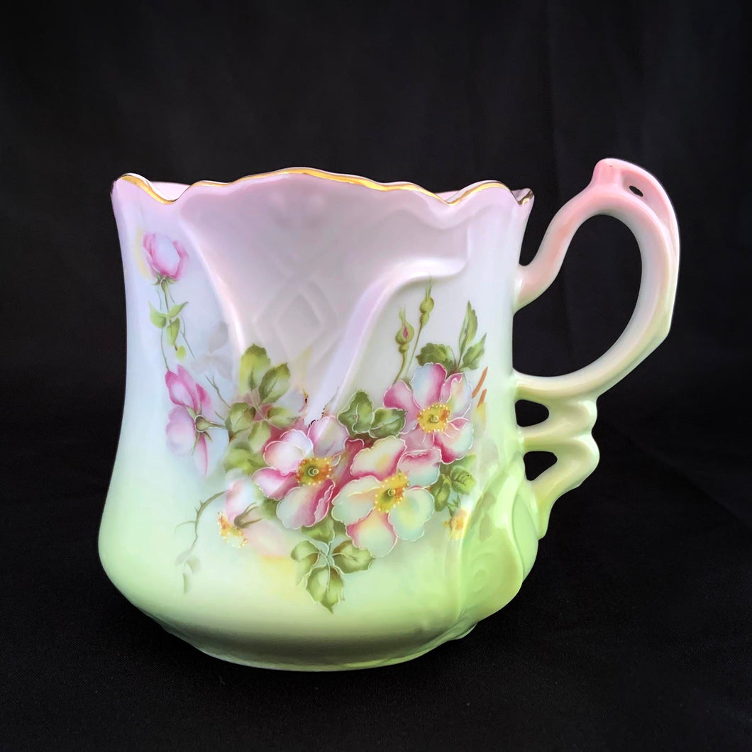 This vintage white porcelain shaving mug is hand painted with lovely pink and green florals with gold rim. Use as intended or repurpose as a toothbrush or make-up brush holder.  Marked 