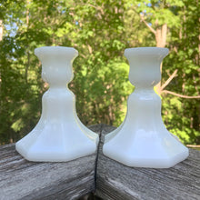 Load image into Gallery viewer, This classic pair of octagonal-shaped milk glass candlestick holders is the epitome of simple elegance and will add a special touch to any table setting. Made by the Anchor Hocking Glass, circa 1970.  In excellent condition, no chips/cracks/repairs.  Measures 3 1/2 x 4 1/8 inches
