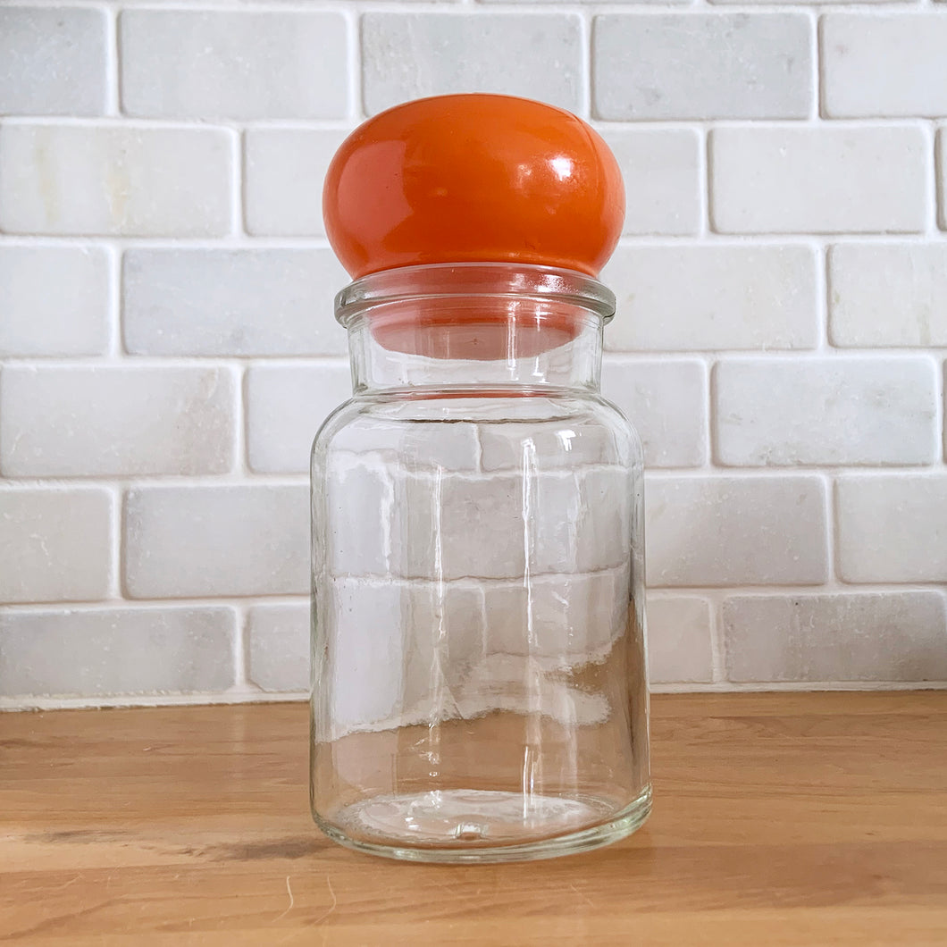 This clear vintage apothecary jar with its orange bubble lid is the perfect opportunity to inject a pop of colour into your decor! Use as a kitchen canister, bathroom apothecary jar or as a great storage jar for office supplies. It has a plastic gasket that makes a great seal if using for food storage. Marked on the bottom 