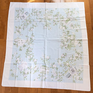 This is a unique textile! Bordered in white this is an absolutely lovely pale aqua blue cotton/linen tablecloth decorated with different white buildings with dark gray or white fences  awash with white roses on gray stems and green leaves. This dreamy table linen will look amazing on any table, or use as a ground cloth for a pretty picnic scene. Easily repurposed as pillows, or a sweet garment.  In excellent condition, free from tears or stains. Circa 1950/60s.  Measures 44 1/2 x 49 1/2 inches