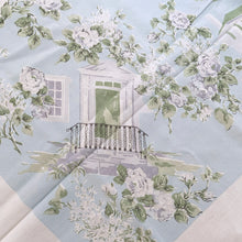 Load image into Gallery viewer, This is a unique textile! Bordered in white this is an absolutely lovely pale aqua blue cotton/linen tablecloth decorated with different white buildings with dark gray or white fences  awash with white roses on gray stems and green leaves. This dreamy table linen will look amazing on any table, or use as a ground cloth for a pretty picnic scene. Easily repurposed as pillows, or a sweet garment.  In excellent condition, free from tears or stains. Circa 1950/60s.  Measures 44 1/2 x 49 1/2 inches
