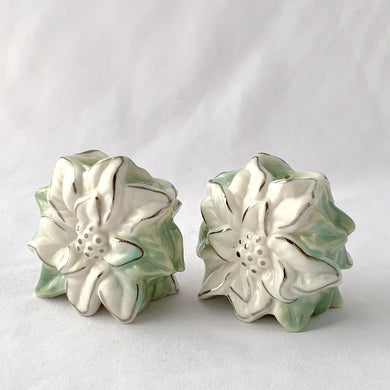 Pretty figural poinsettia set of salt and pepper shakers. These are painted in white with pale green and silver accents. Perfect for anytime of year!  In excellent condition, no chips or cracks. Nicely weighted and appear to be in new old stock.