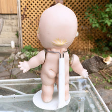 Load image into Gallery viewer, Rare porcelain bisque Kewpie Doll figurine with moveable string jointed arms. It&#39;s difficult to find this specific one standing with its legs apart which is what makes this one rare.  Excellent vintage condition, free from chips or cracks. String could be tightened.  This delightful little cutie stands at approximately 7&quot; inches tall and comes with a metal stand.
