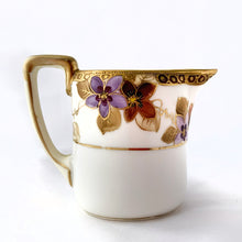 Load image into Gallery viewer, Elegant and beautifully hand painted antique porcelain oval-shaped creamer and covered sugar bowl with clematis flowers in shades of purple and gold vines with gold moriage details. The base of each piece show the Noritake stamp called the Maruki mark which was produced between 1906 to 1925. The sugar bowl is in excellent condition free from chips, cracks or repairs and has minor wear to the gold band on the lid, see photos. The creamer has a vertical crack on the body near the handle.
