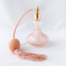 Load image into Gallery viewer, Beautiful vintage pressed pink stain glass perfume bottle with a feminine vertically ribbed shape, tasseled atomizer ball and gold toned fittings. Made in Taiwan, circa 1970s.  In like-new condition. Original stickers present.  Measures 3&quot; x 5-1/2&quot;
